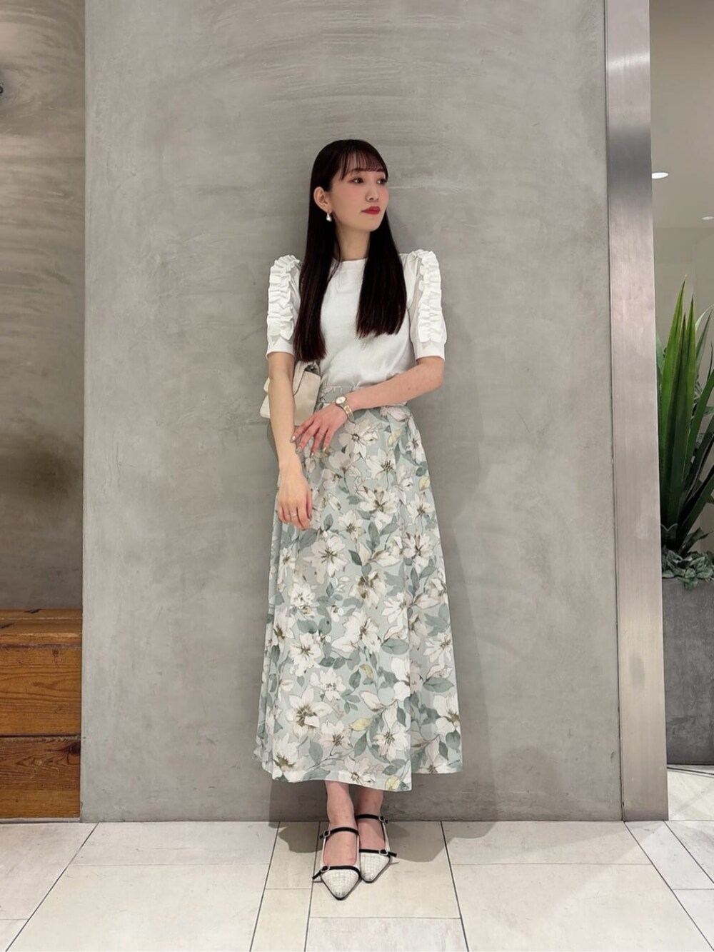 グリーン系のスカート、ホワイト系のショルダーバッグ、ホワイト系のニット/セーターを着用したレディースの春コーディネートの3枚目の写真