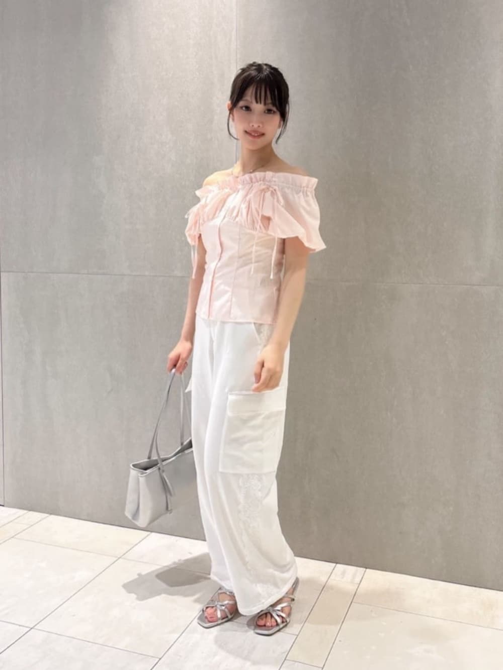 シルバー系のパンプス、シルバー系のショルダーバッグ、ピンク系のシャツ/ブラウスを着用したレディースの夏コーディネートの2枚目の写真