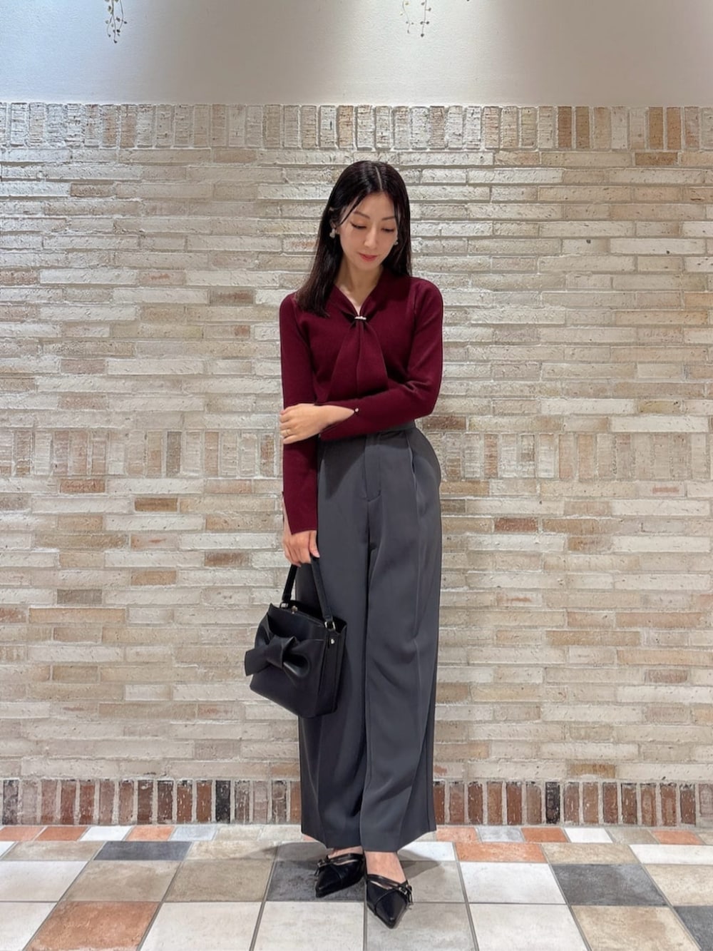 レッド系のニット/セーター、ブラック系のテーラードジャケット、グレー系のその他パンツを着用したレディースの秋コーディネートの3枚目の写真