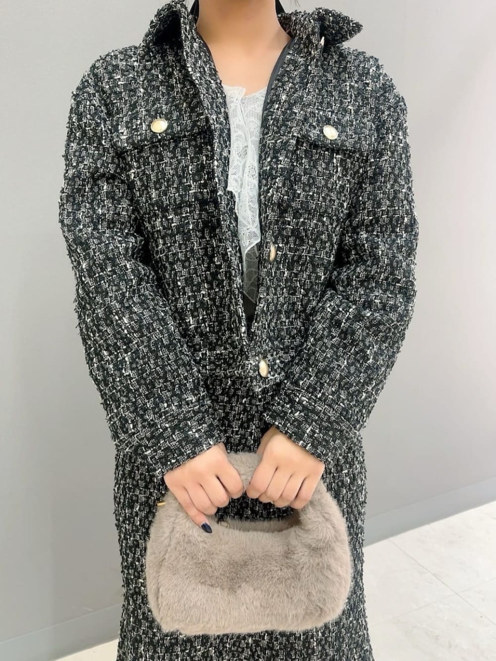 ベージュ系のハンドバッグ、ブラック系のテーラードジャケット、ブラック系のスカートを着用したレディースの秋コーディネートの3枚目の写真