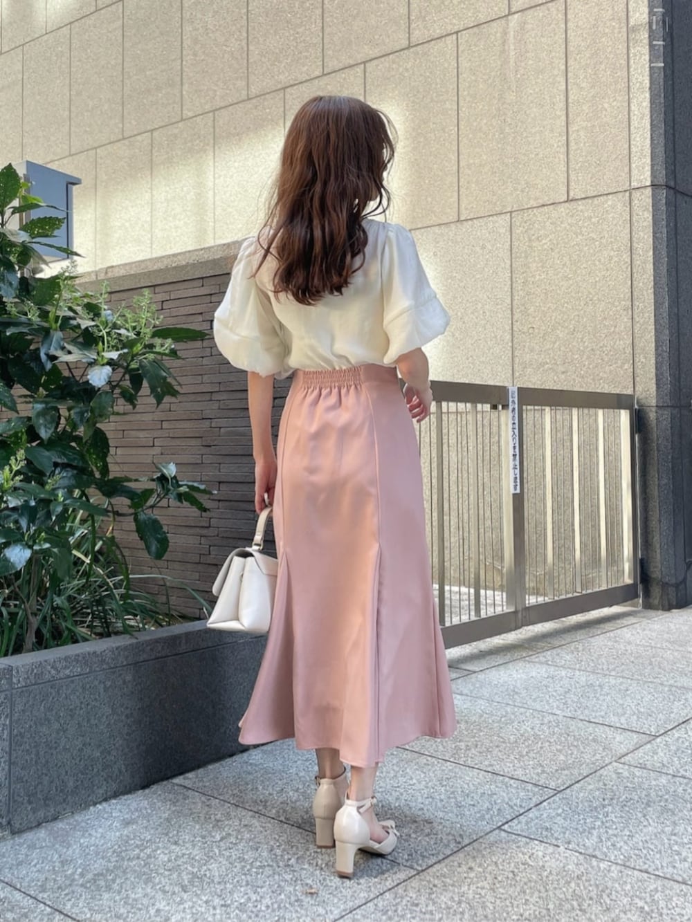 ブラック系のパンプス、ホワイト系のシャツ/ブラウス、ピンク系のスカートを着用したレディースの春コーディネートの3枚目の写真