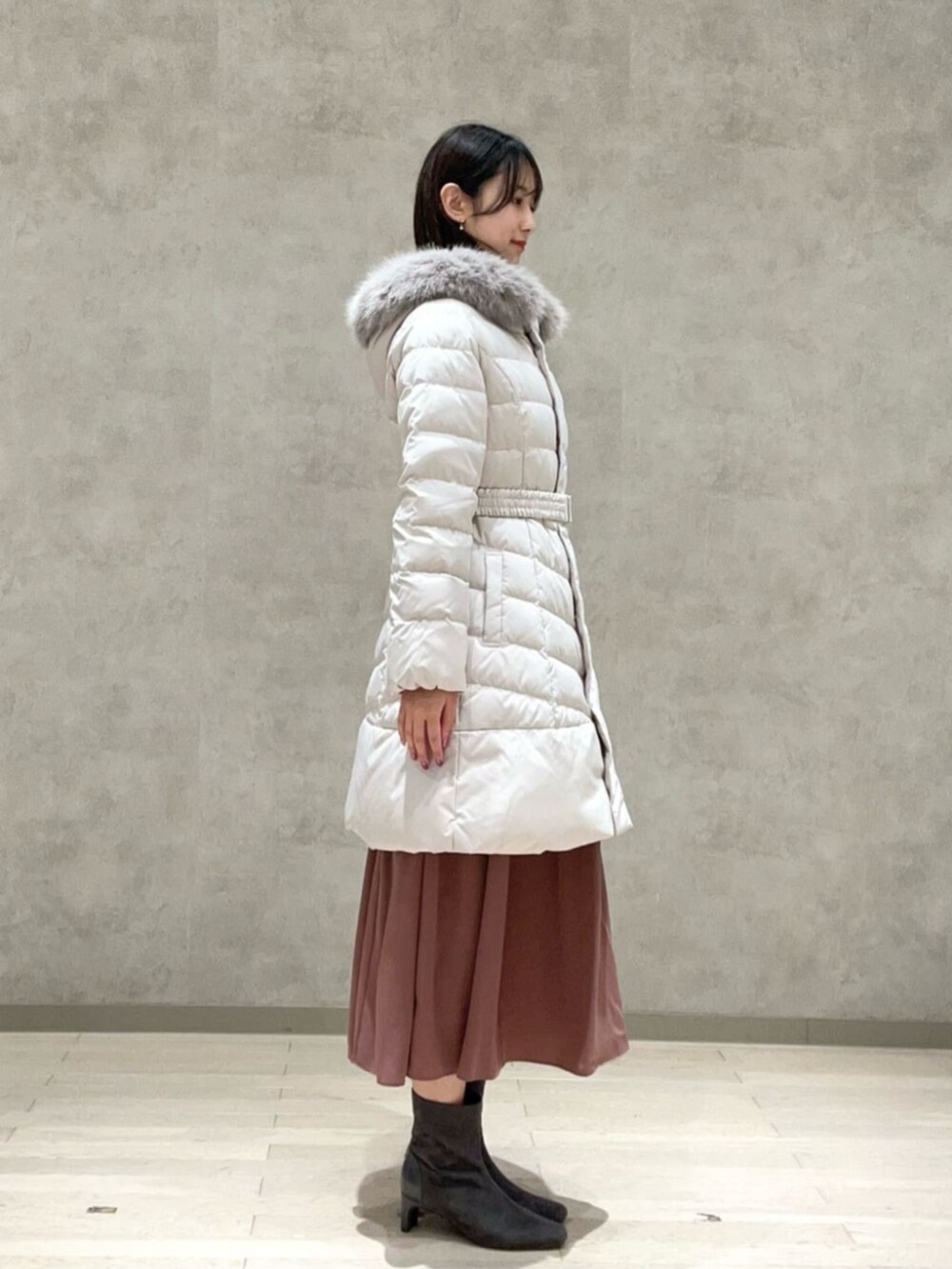 ホワイト系のダウンジャケット/コート、ピンク系のワンピースを着用したレディースの冬コーディネートの2枚目の写真
