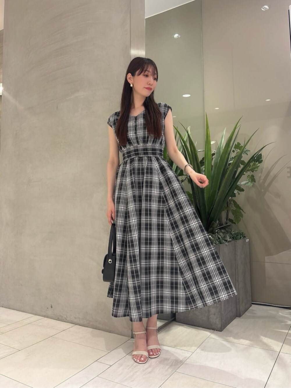 ブラック系のショルダーバッグ、ブラック系のワンピースを着用したレディースの春コーディネートの2枚目の写真