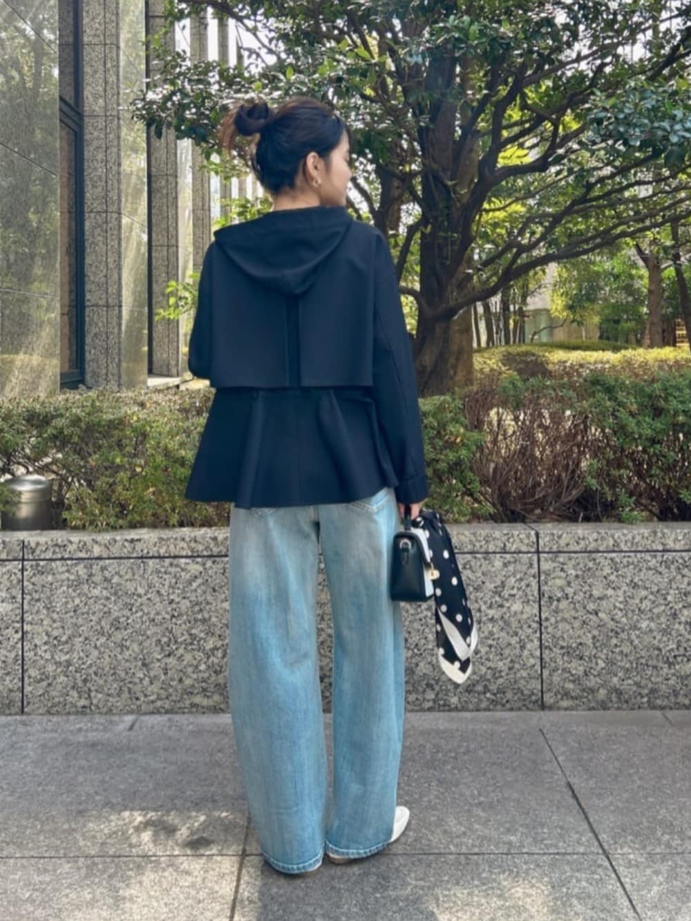 ブラック系のマウンテンパーカー、ホワイト系のTシャツ/カットソー、ブルー系のデニムパンツを着用したレディースの冬コーディネートの3枚目の写真