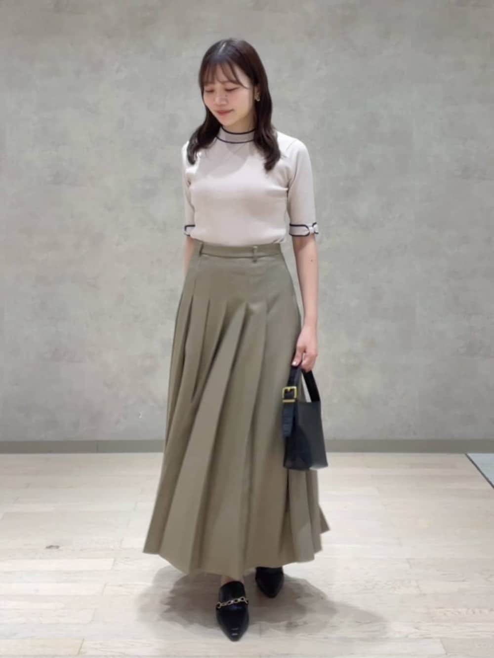 ブラウン系のテーラードジャケット、ベージュ系のニット/セーター、ブラウン系のスカートを着用したレディースの秋コーディネートの3枚目の写真