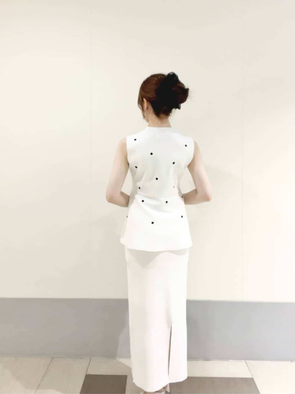 ブラック系のショルダーバッグ、ホワイト系のワンピース、シルバー系のパンプスを着用したレディースの夏コーディネートの3枚目の写真