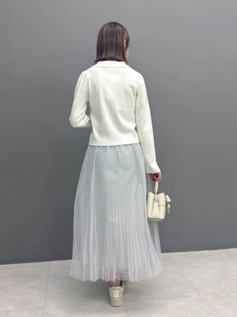 ホワイト系のニット/セーター、グレー系のスカート、ホワイト系のショルダーバッグを着用したレディースの冬コーディネートの3枚目の写真