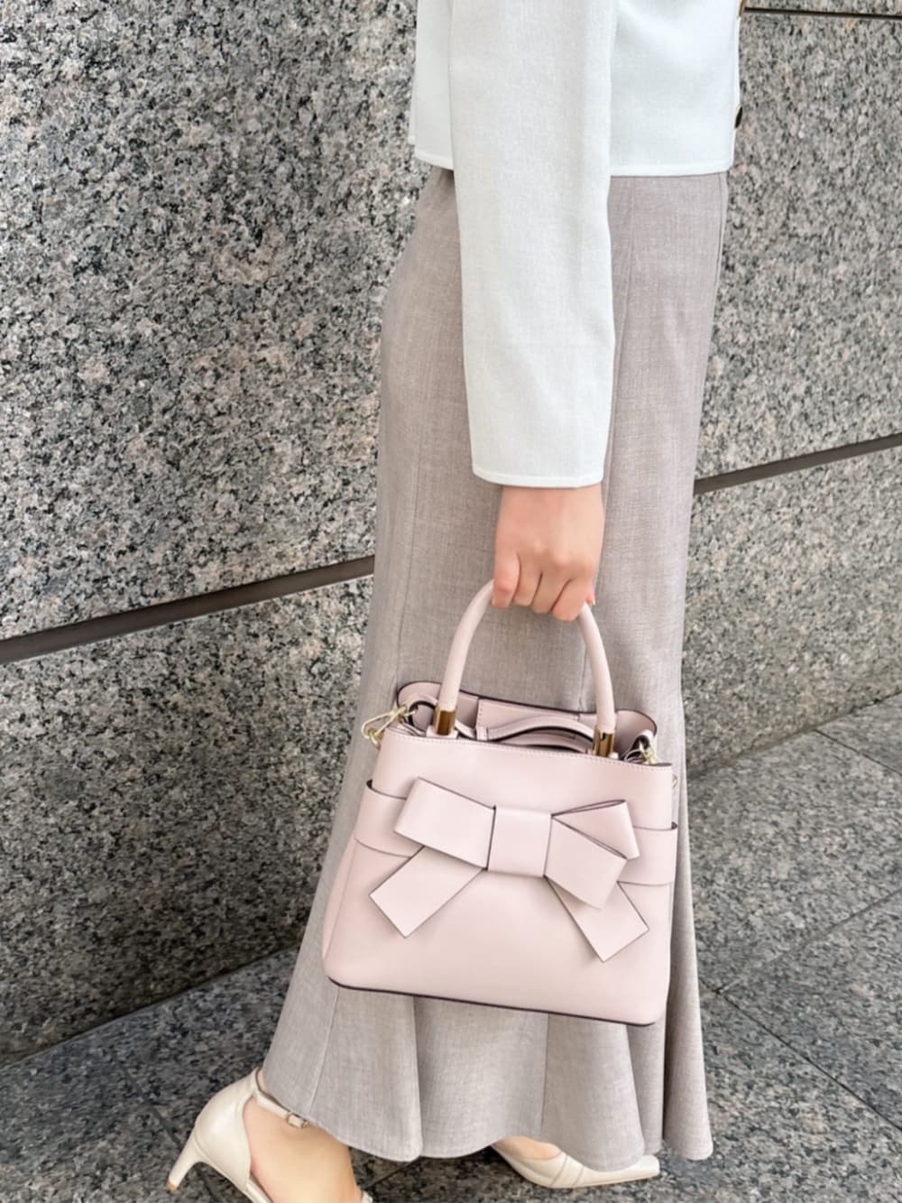 ホワイト系のパンプス、ホワイト系のニット/セーター、ブラウン系のスカートを着用したレディースの冬コーディネートの3枚目の写真