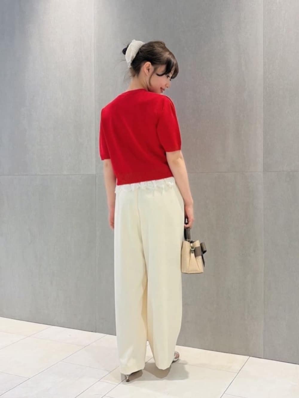 シルバー系のパンプス、ブラウン系のショルダーバッグ、ホワイト系のその他パンツを着用したレディースの夏コーディネートの3枚目の写真