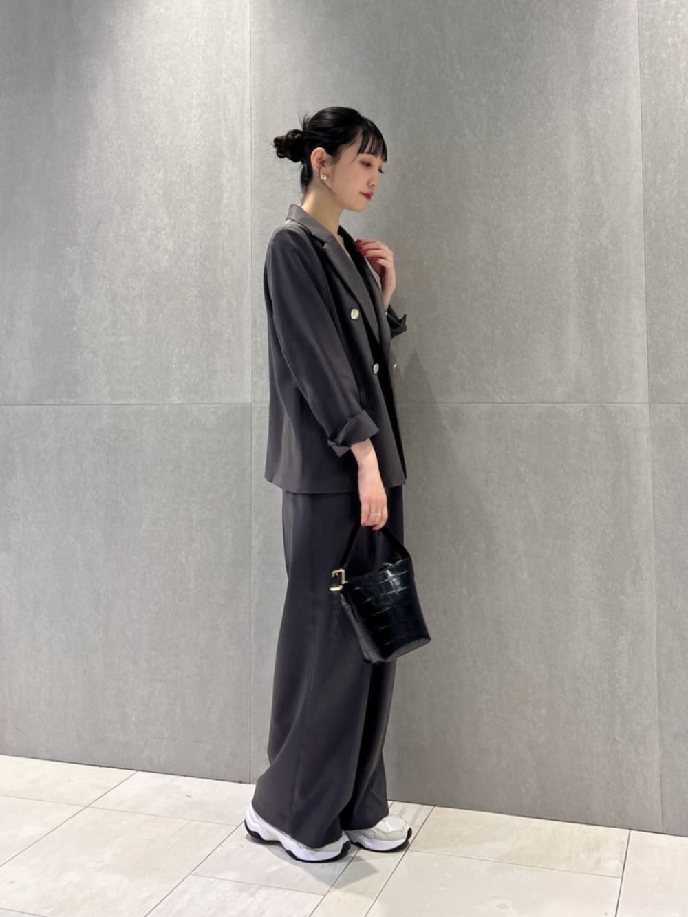 グレー系のテーラードジャケット、ブラック系のキャミソール、グレー系のその他パンツを着用したレディースの冬コーディネートの2枚目の写真