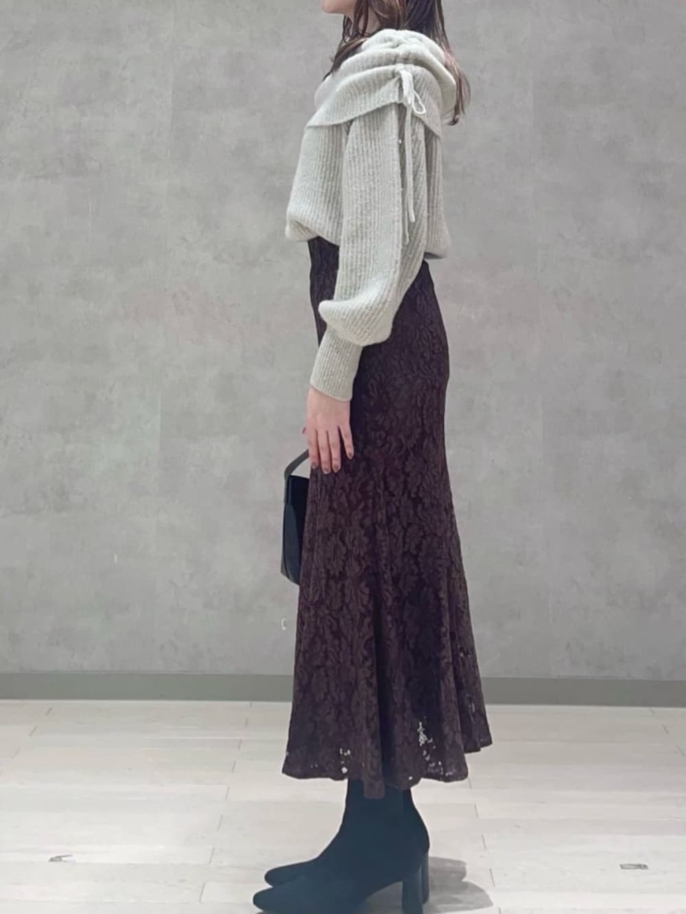 ベージュ系のニット/セーター、ブラウン系のスカートを着用したレディースの冬コーディネートの2枚目の写真