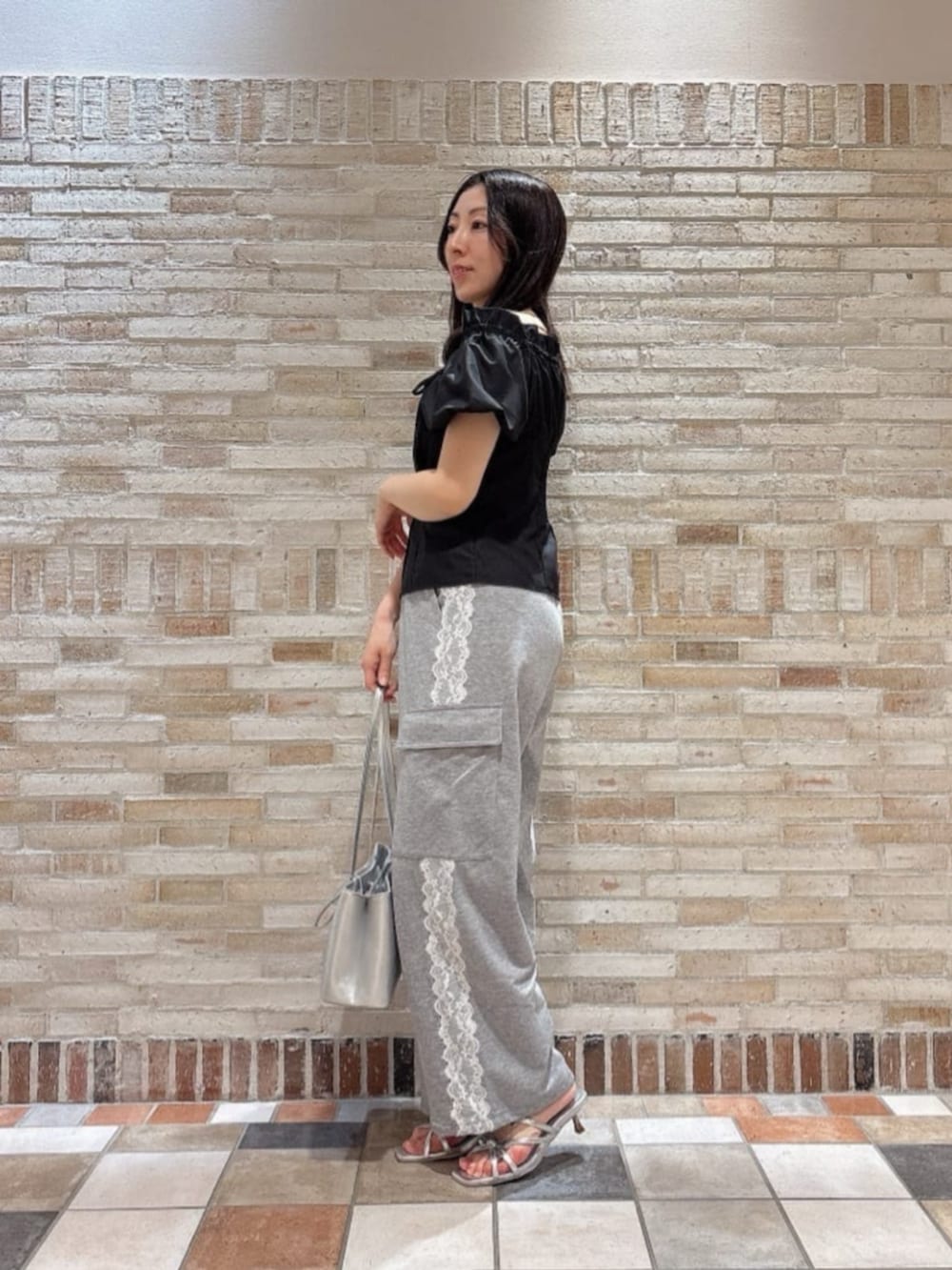 シルバー系のパンプス、シルバー系のショルダーバッグ、ブラック系のシャツ/ブラウスを着用したレディースの夏コーディネートの3枚目の写真