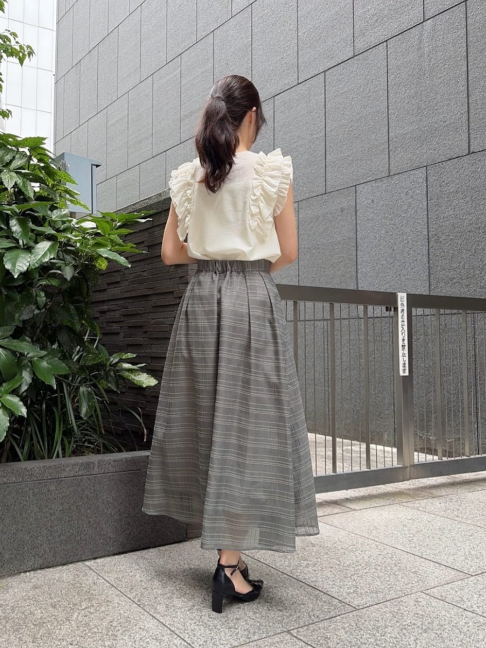 ブラック系のパンプス、ホワイト系のショルダーバッグ、ホワイト系のシャツ/ブラウスを着用したレディースの夏コーディネートの3枚目の写真