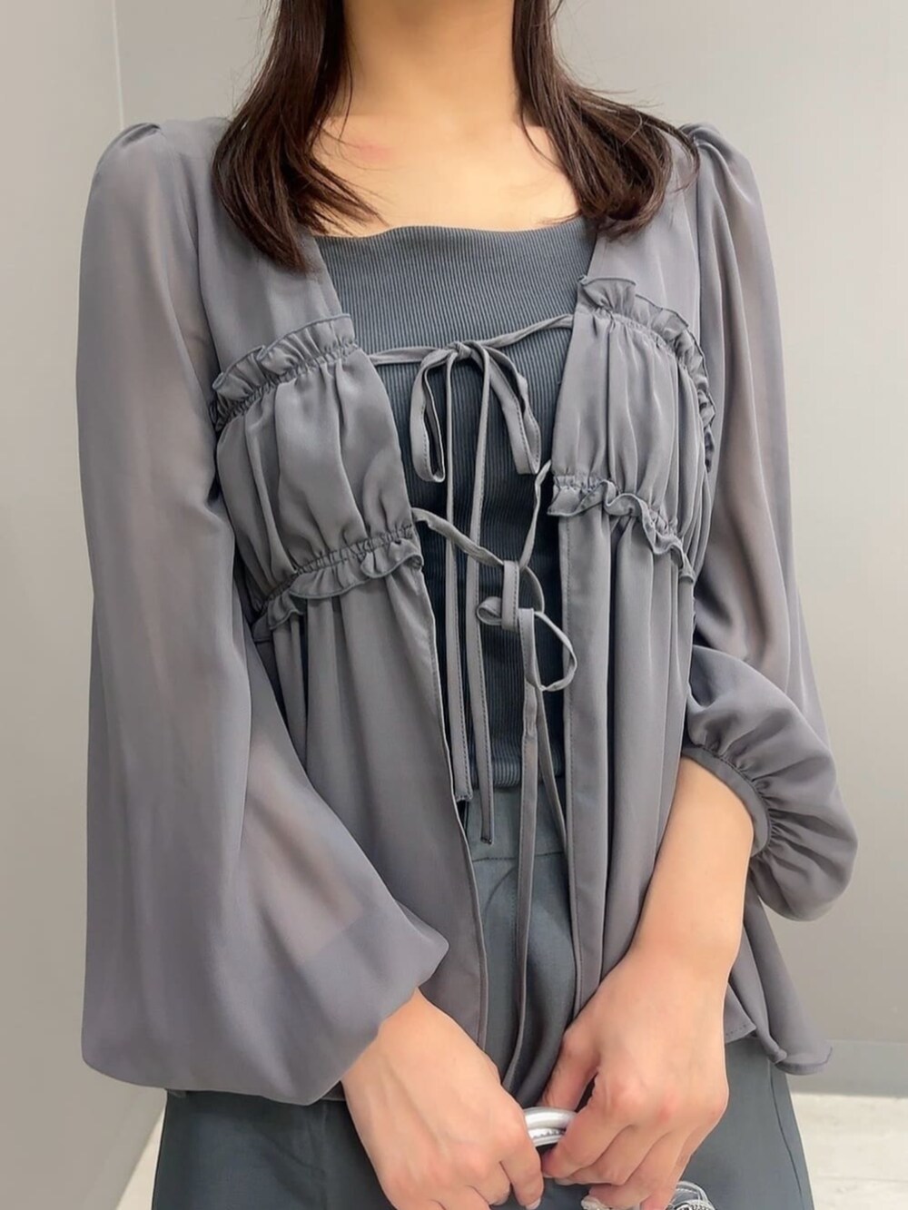 シルバー系のトートバッグ、グレー系のシャツ/ブラウス、グレー系のTシャツ/カットソーを着用したレディースの夏コーディネートの3枚目の写真