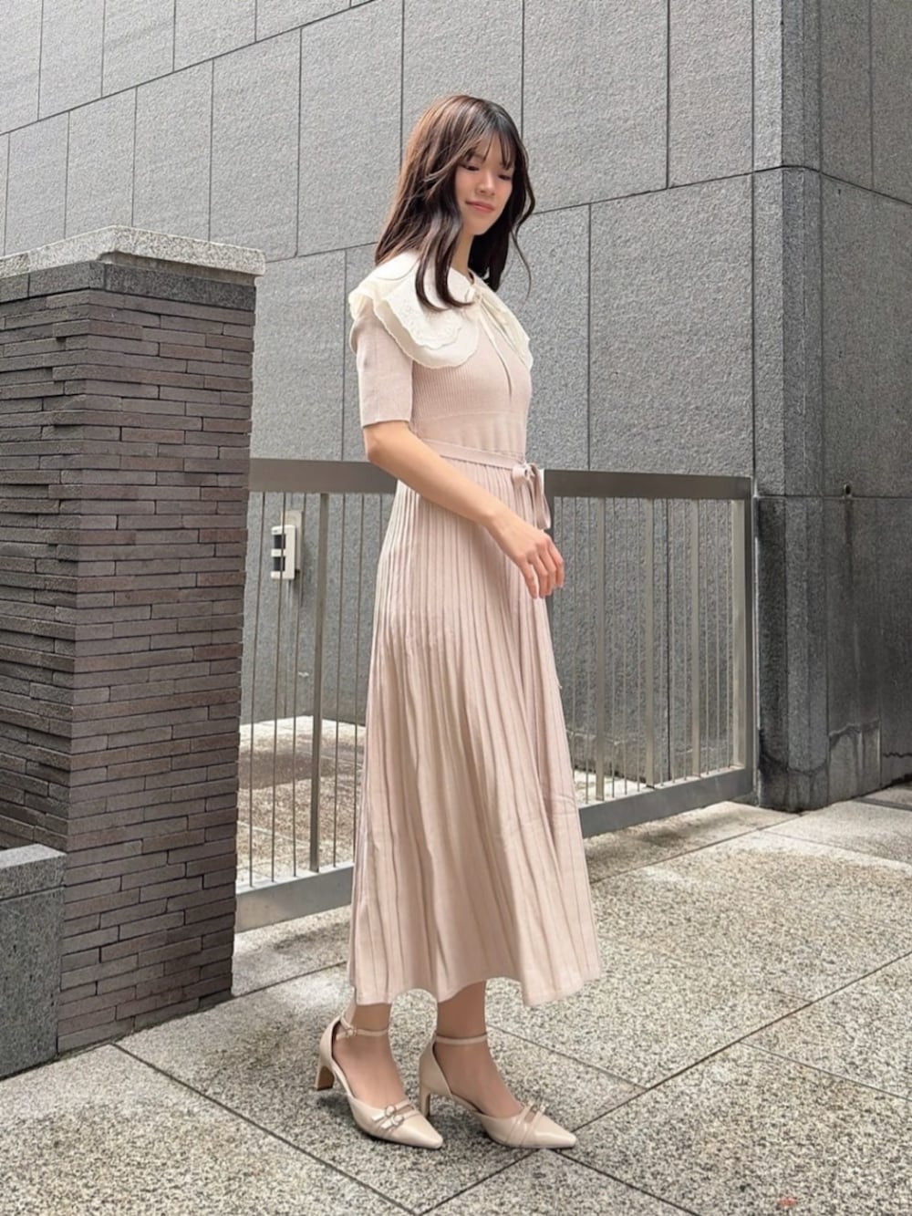 ホワイト系のショルダーバッグ、ベージュ系のパンプス、ベージュ系のワンピースを着用したレディースの春コーディネートの2枚目の写真