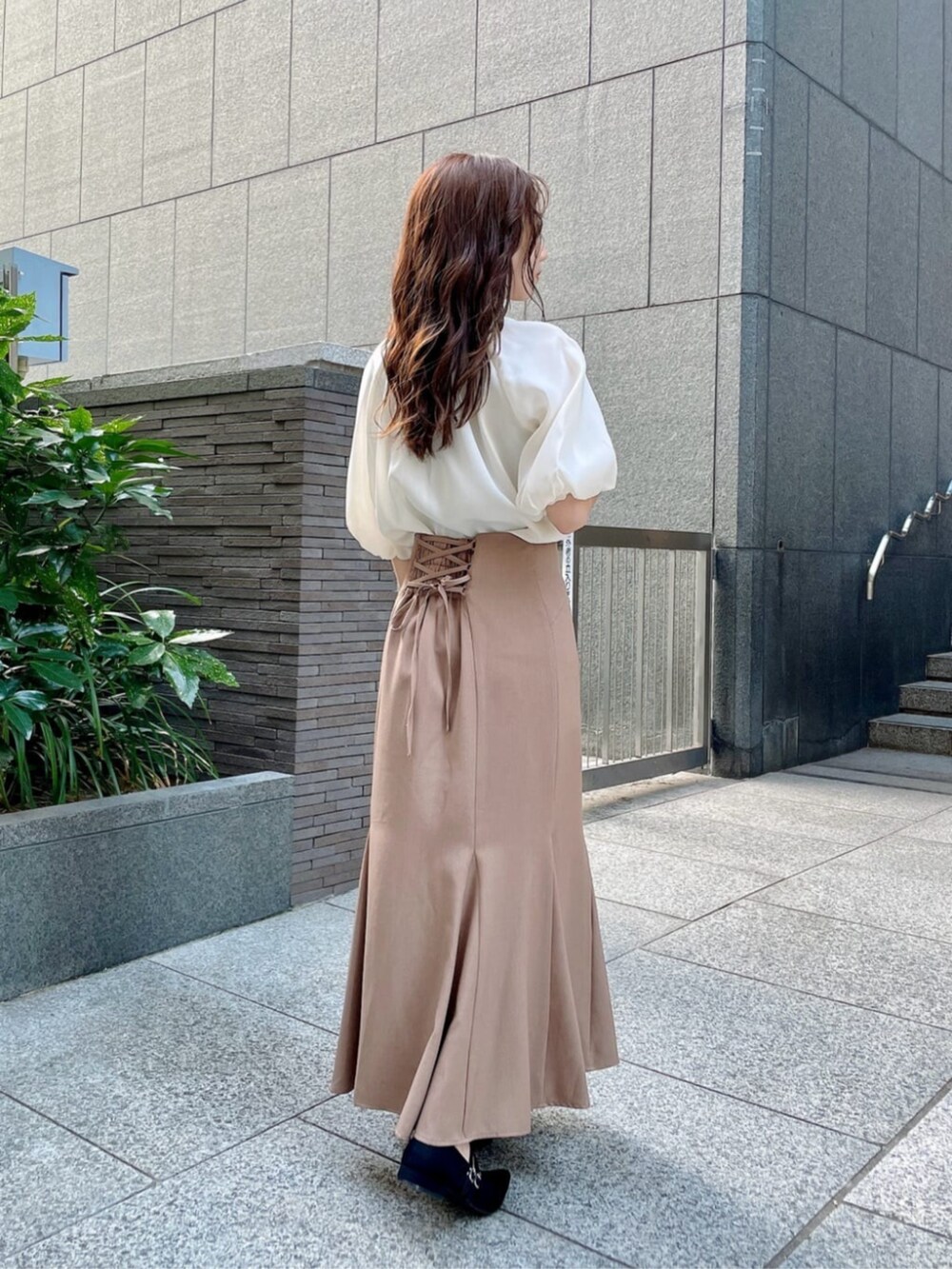 ホワイト系のショルダーバッグ、ホワイト系のシャツ/ブラウス、ブラウン系のスカートを着用したレディースの秋コーディネートの2枚目の写真