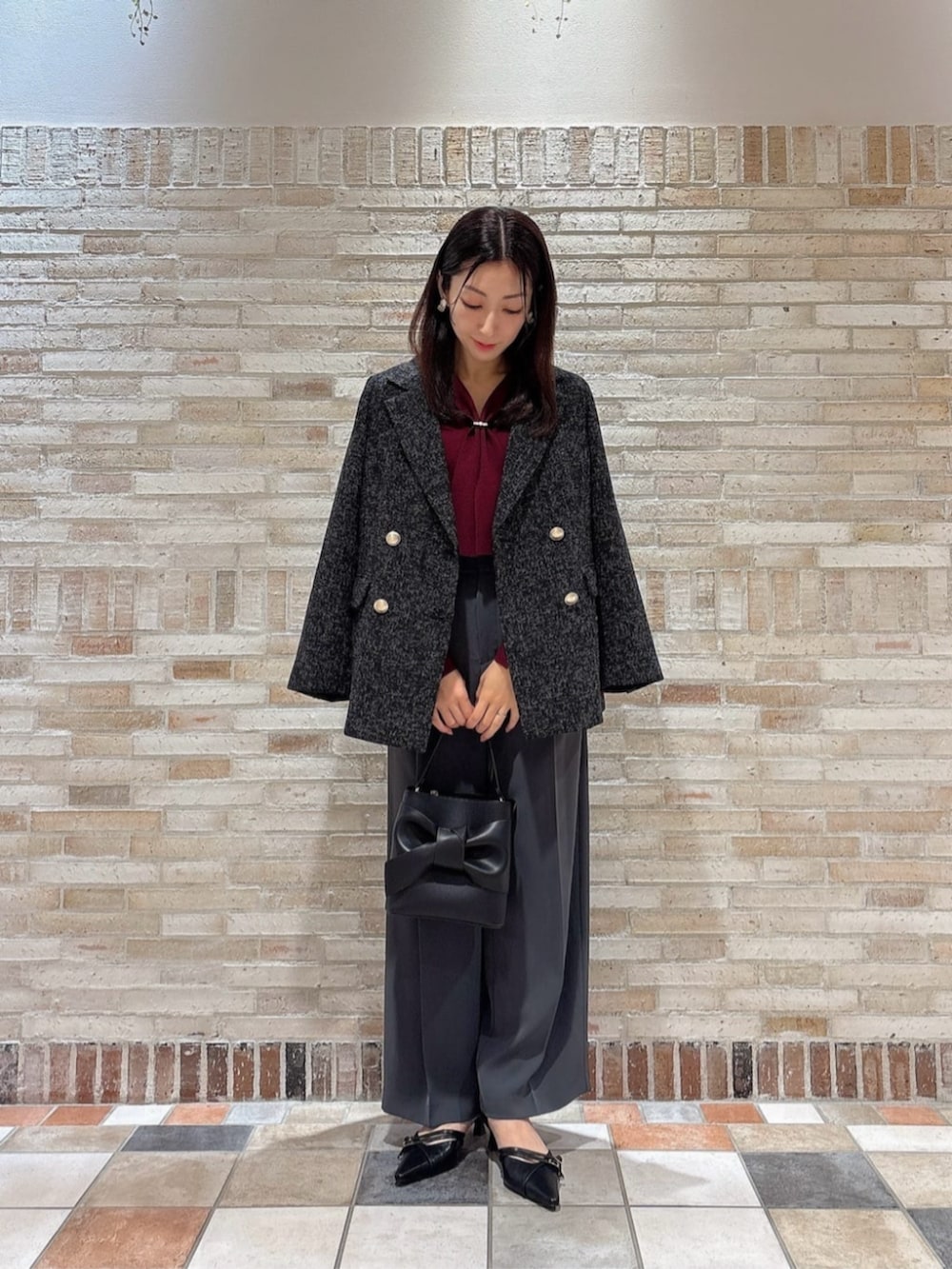レッド系のニット/セーター、ブラック系のテーラードジャケット、グレー系のその他パンツを着用したレディースの秋コーディネートの2枚目の写真