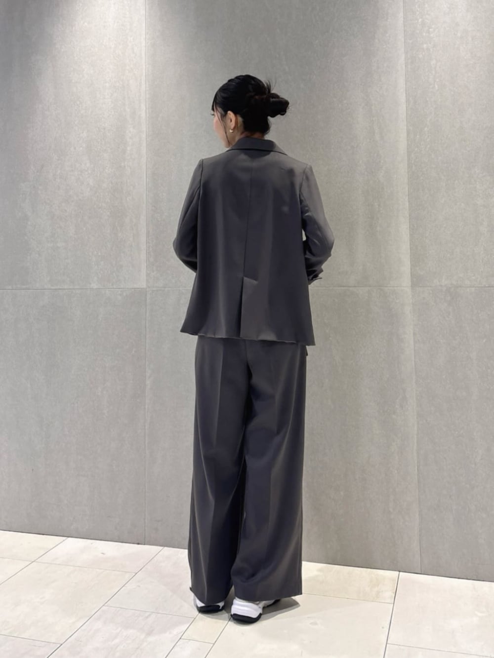 グレー系のテーラードジャケット、ブラック系のキャミソール、グレー系のその他パンツを着用したレディースの冬コーディネートの3枚目の写真