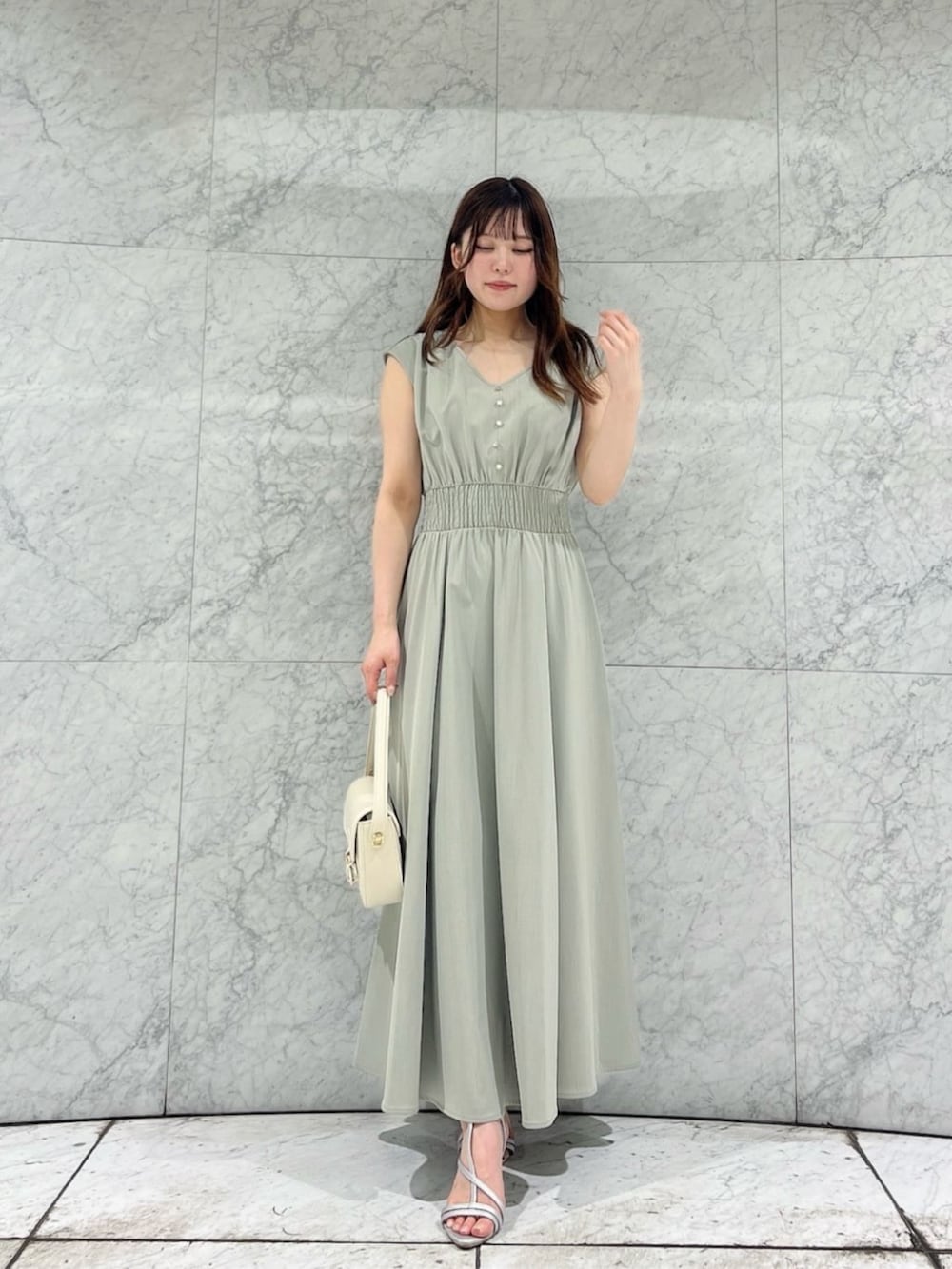 シルバー系のパンプス、ホワイト系のショルダーバッグ、ホワイト系のテーラードジャケットを着用したレディースの夏コーディネートの3枚目の写真