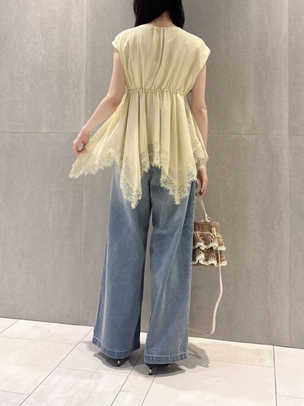 イエロー系のシャツ/ブラウス、ブルー系のその他パンツ、ベージュ系のショルダーバッグを着用したレディースの春コーディネートの3枚目の写真