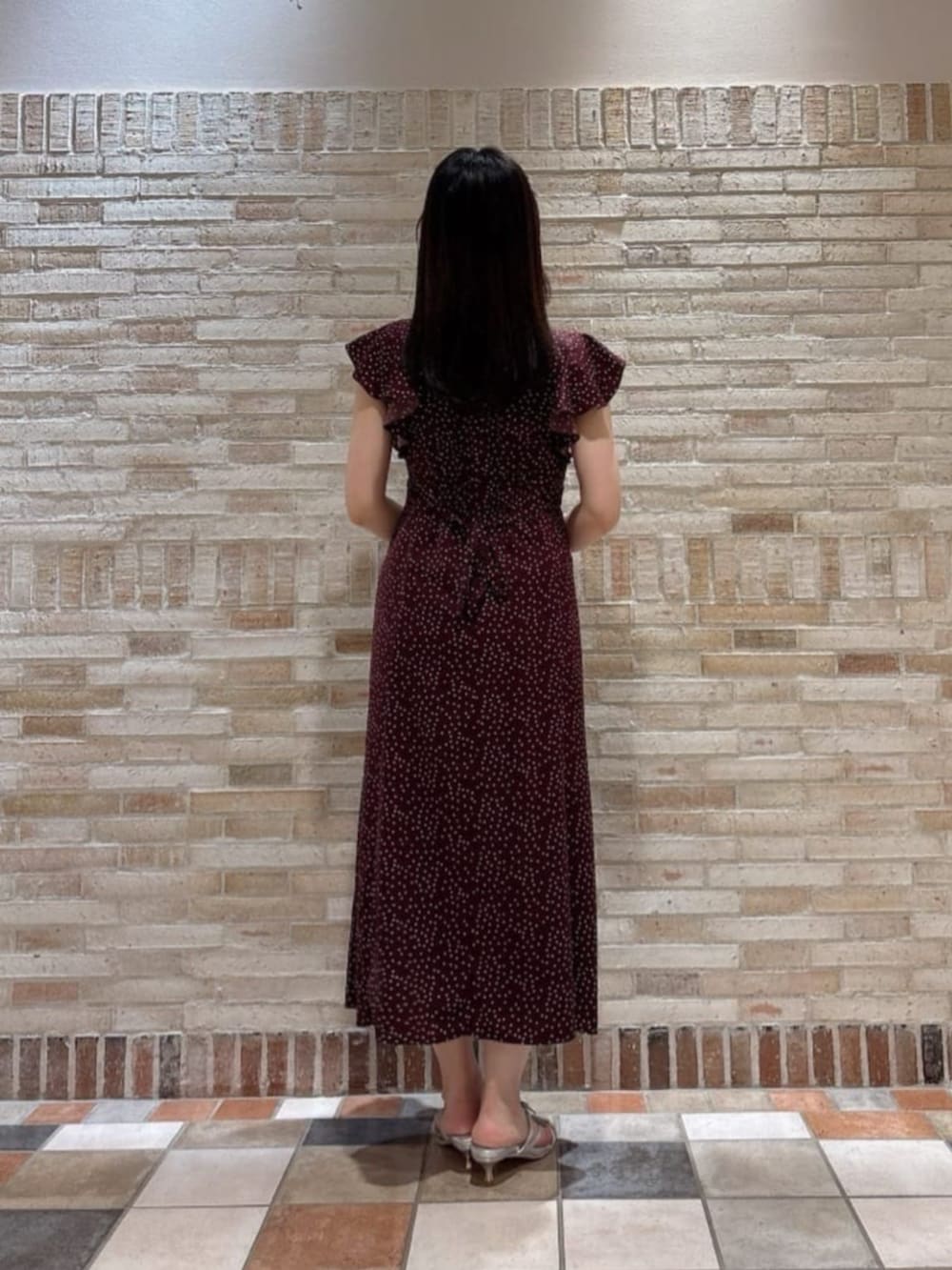 シルバー系のパンプス、ブラック系のショルダーバッグ、ブラウン系のワンピースを着用したレディースの夏コーディネートの3枚目の写真