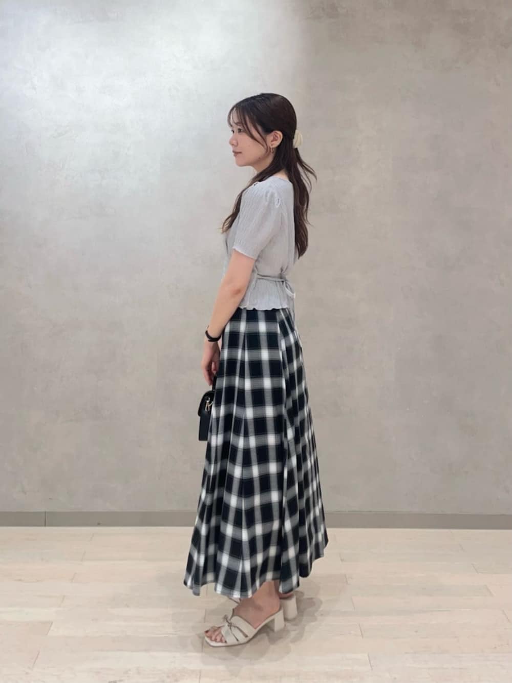 ブラック系のショルダーバッグ、グレー系のTシャツ/カットソー、ブラック系のスカートを着用したレディースの夏コーディネートの3枚目の写真
