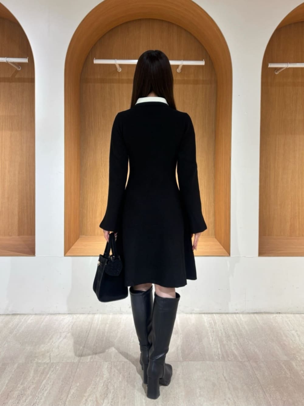 ブラック系のワンピース、ブラック系のショルダーバッグを着用したレディースの冬コーディネートの2枚目の写真