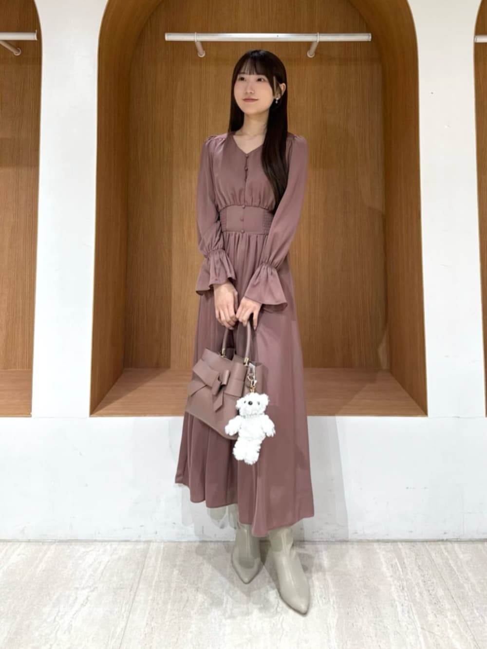 ピンク系のワンピースを着用したレディースの冬コーディネートの2枚目の写真