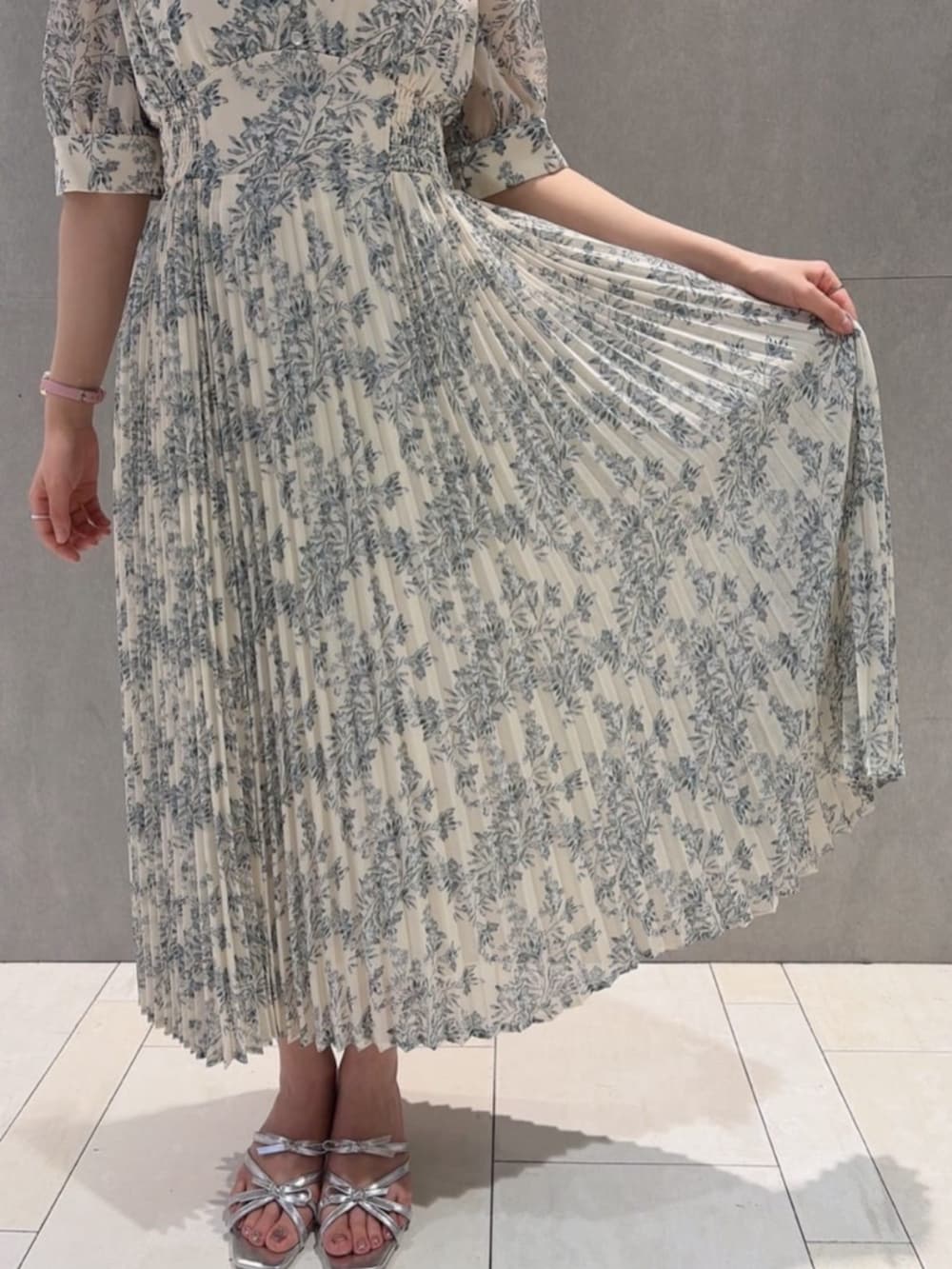 シルバー系のパンプス、ホワイト系のワンピース、ベージュ系のショルダーバッグを着用したレディースの夏コーディネートの3枚目の写真