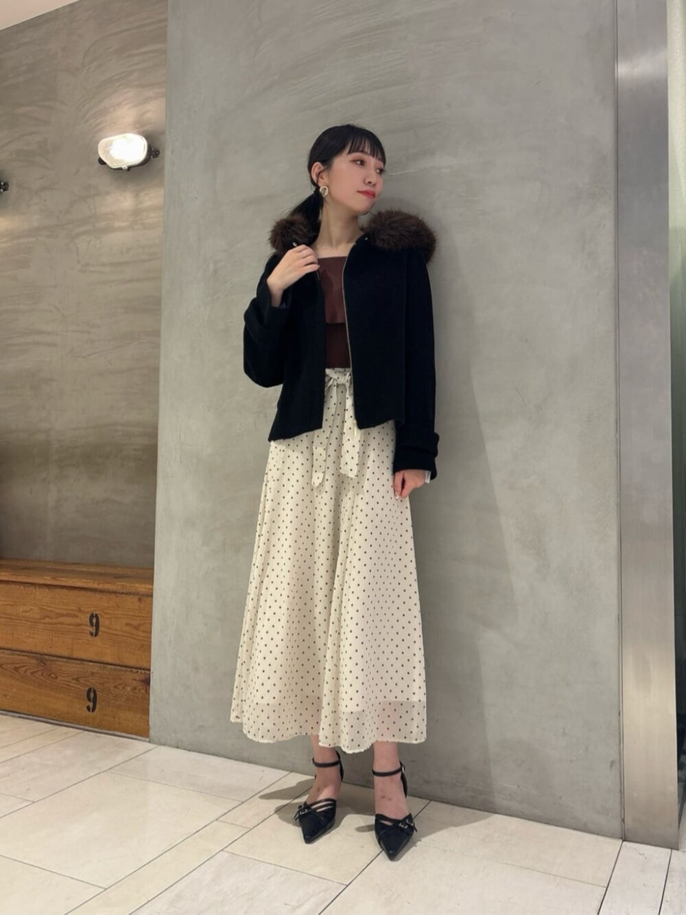 ホワイト系のワンピース、ブラック系のパンプス、ブラック系のブルゾンを着用したレディースの秋コーディネートの2枚目の写真