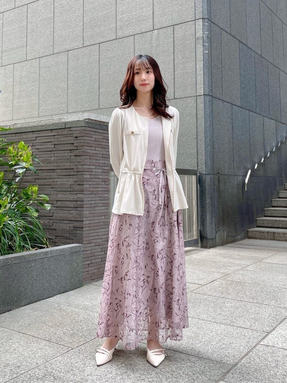 グレー系のワンピース、ホワイト系のブルゾンを着用したレディースの春コーディネートの2枚目の写真