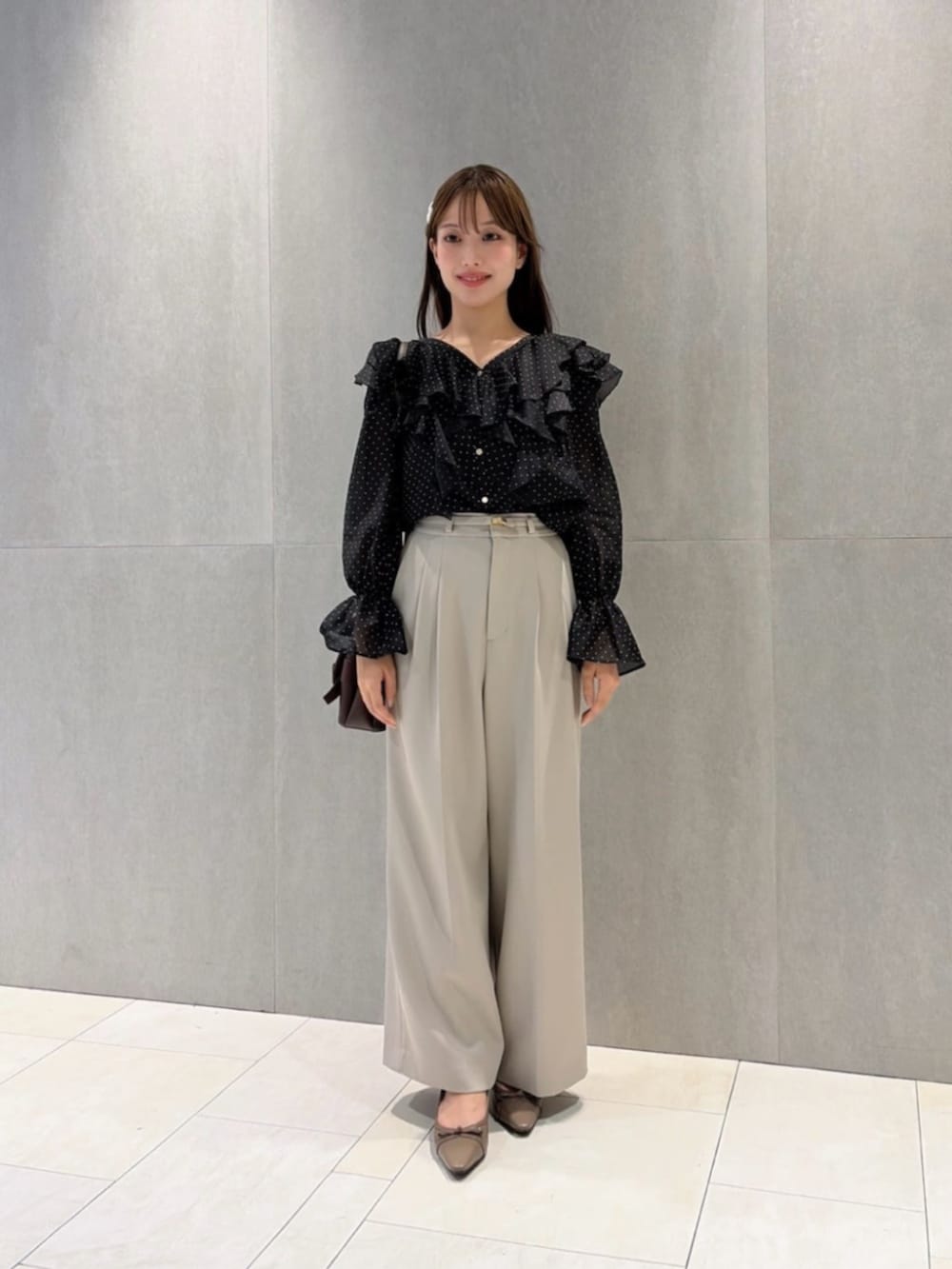 ブラウン系のショルダーバッグ、ブラック系のシャツ/ブラウス、グレー系のその他パンツを着用したレディースの秋コーディネートの2枚目の写真