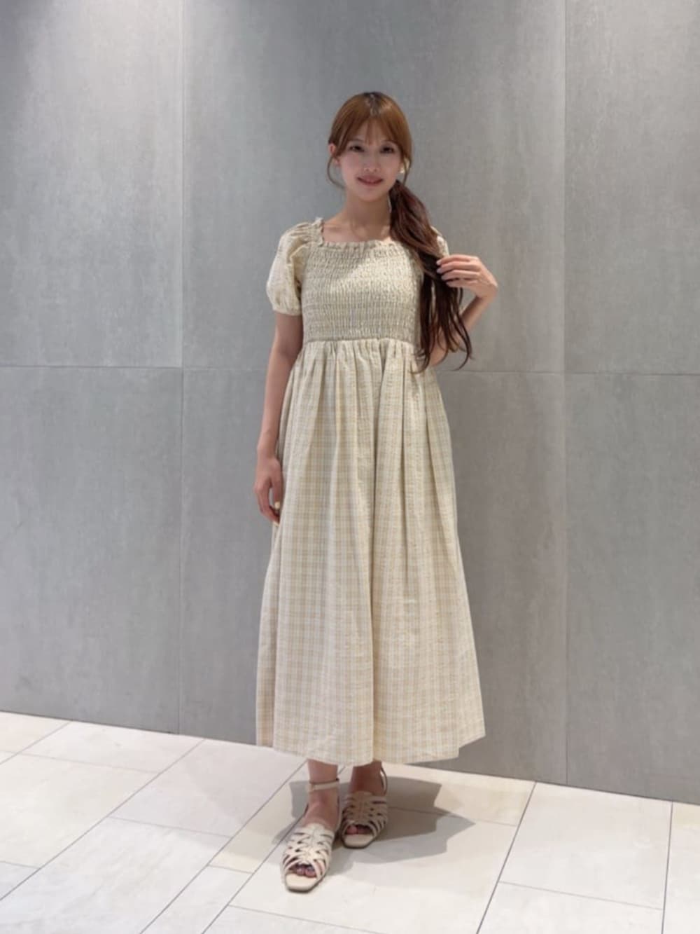 ホワイト系のパンプス、ベージュ系のワンピースを着用したレディースの秋コーディネートの2枚目の写真