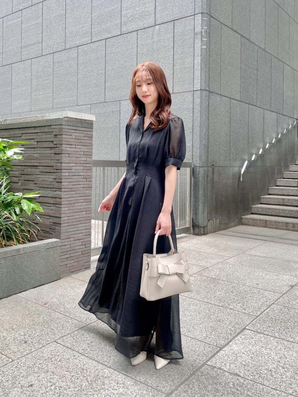 ホワイト系のショルダーバッグ、ブラック系のワンピースを着用したレディースの夏コーディネートの2枚目の写真