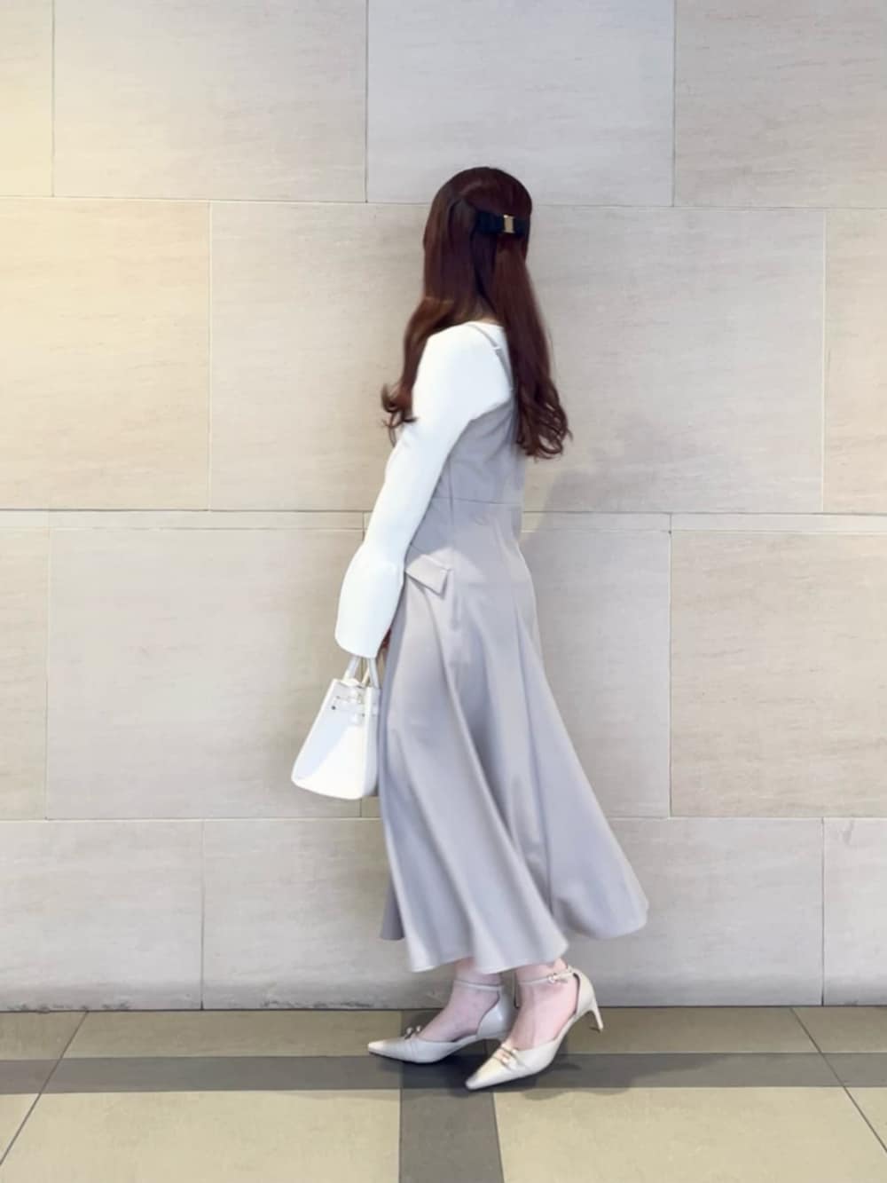 ベージュ系のパンプス、ホワイト系のニット/セーター、ベージュ系のジャンパースカートを着用したレディースの春コーディネートの3枚目の写真