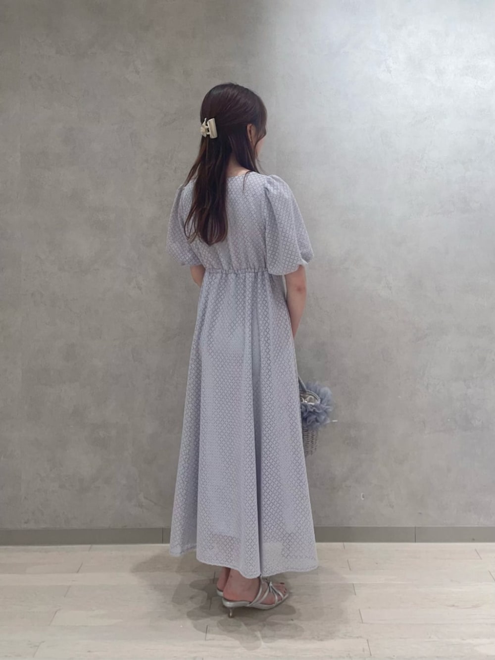 シルバー系のパンプス、グレー系のショルダーバッグ、グレー系のワンピースを着用したレディースの春コーディネートの2枚目の写真