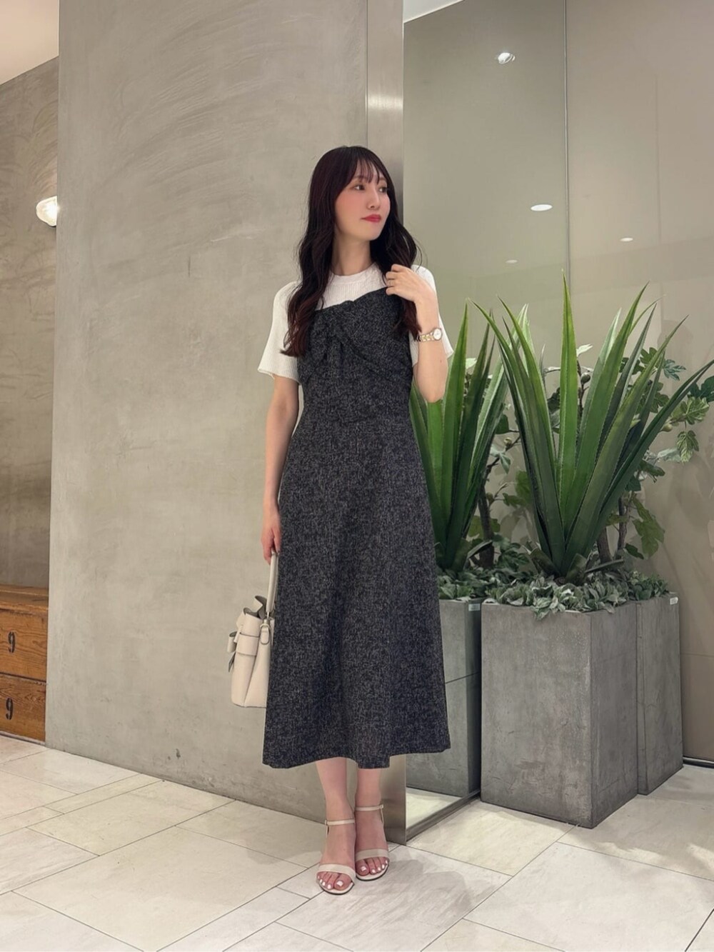 ホワイト系のショルダーバッグ、ブラック系のワンピースを着用したレディースの春コーディネートの3枚目の写真