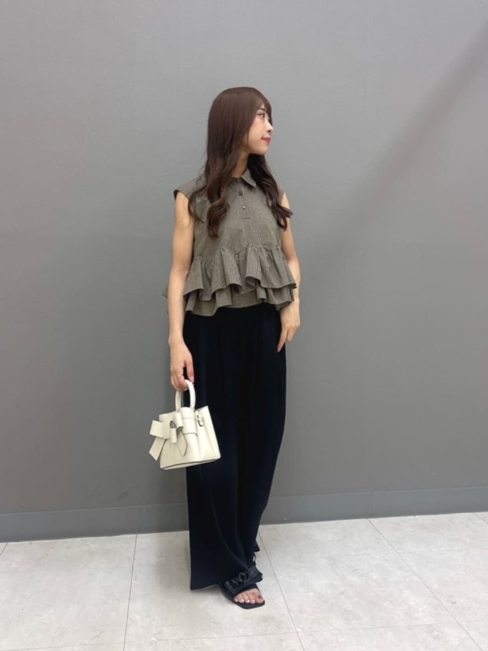 ブラック系のその他パンツ、ホワイト系のショルダーバッグ、ブラウン系のシャツ/ブラウスを着用したレディースの夏コーディネートの3枚目の写真