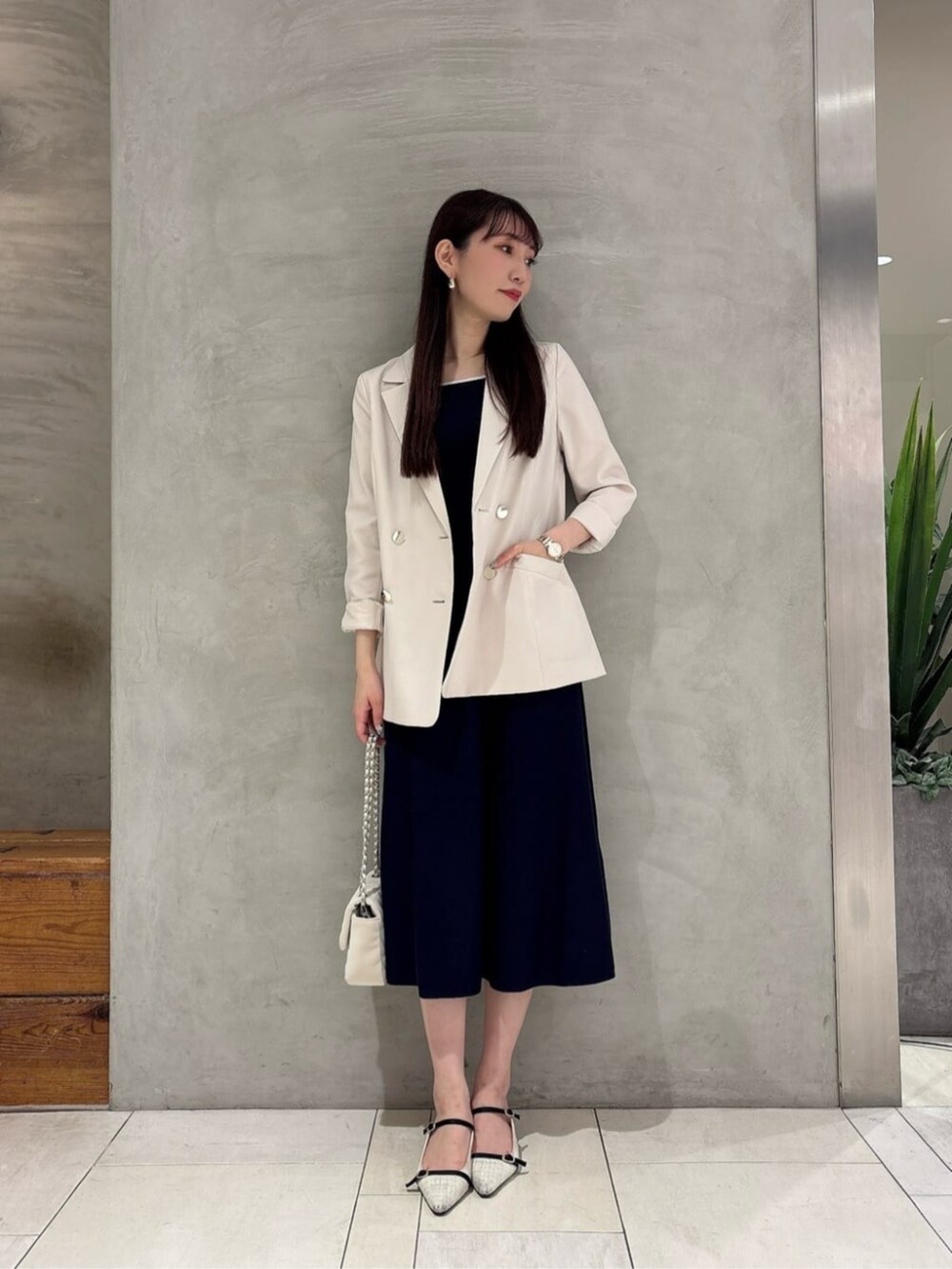 ホワイト系のテーラードジャケット、ホワイト系のショルダーバッグ、ブルー系のワンピースを着用したレディースの春コーディネートの3枚目の写真