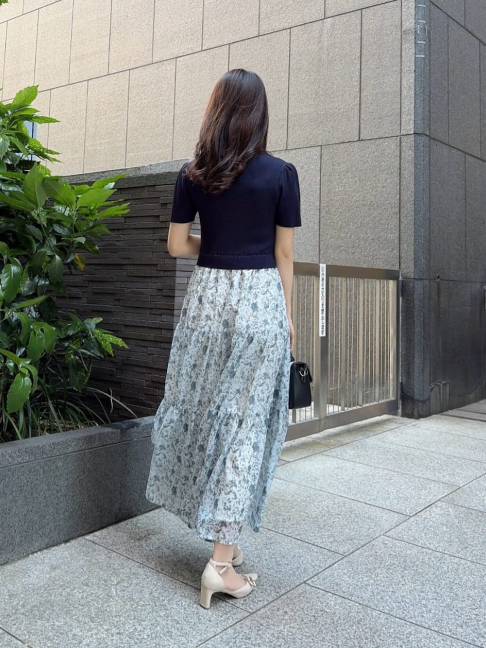 ベージュ系のパンプス、ブラック系のショルダーバッグ、ブルー系のワンピースを着用したレディースの春コーディネートの3枚目の写真