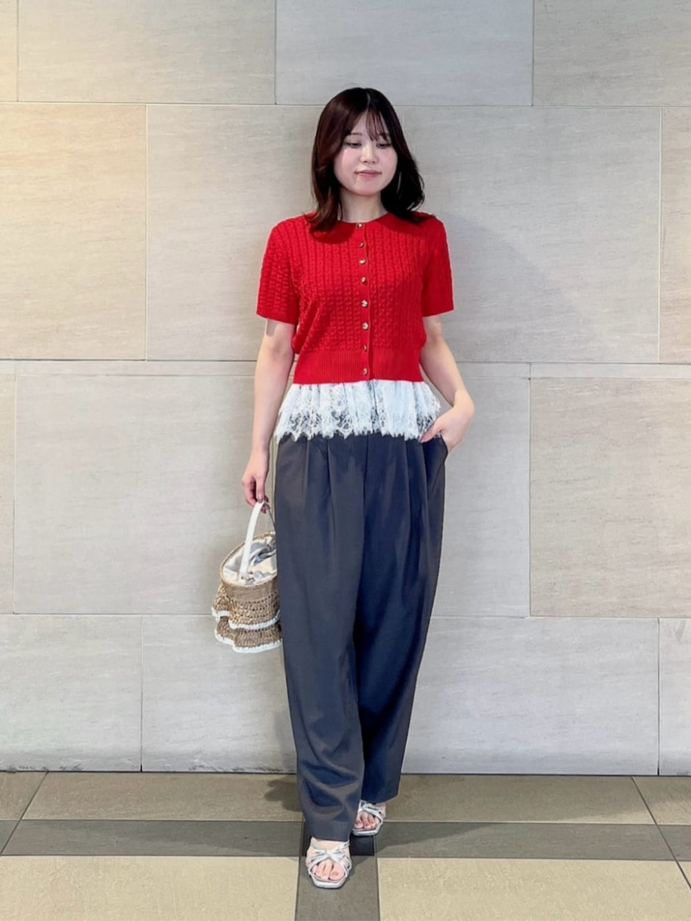 シルバー系のパンプス、ベージュ系のショルダーバッグ、レッド系のニット/セーターを着用したレディースの夏コーディネートの2枚目の写真