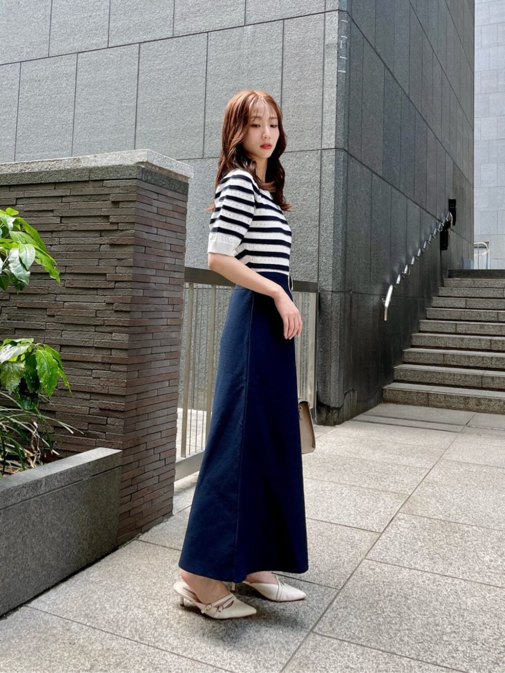 ブルー系のワンピース、ブラウン系のショルダーバッグを着用したレディースの春コーディネートの3枚目の写真