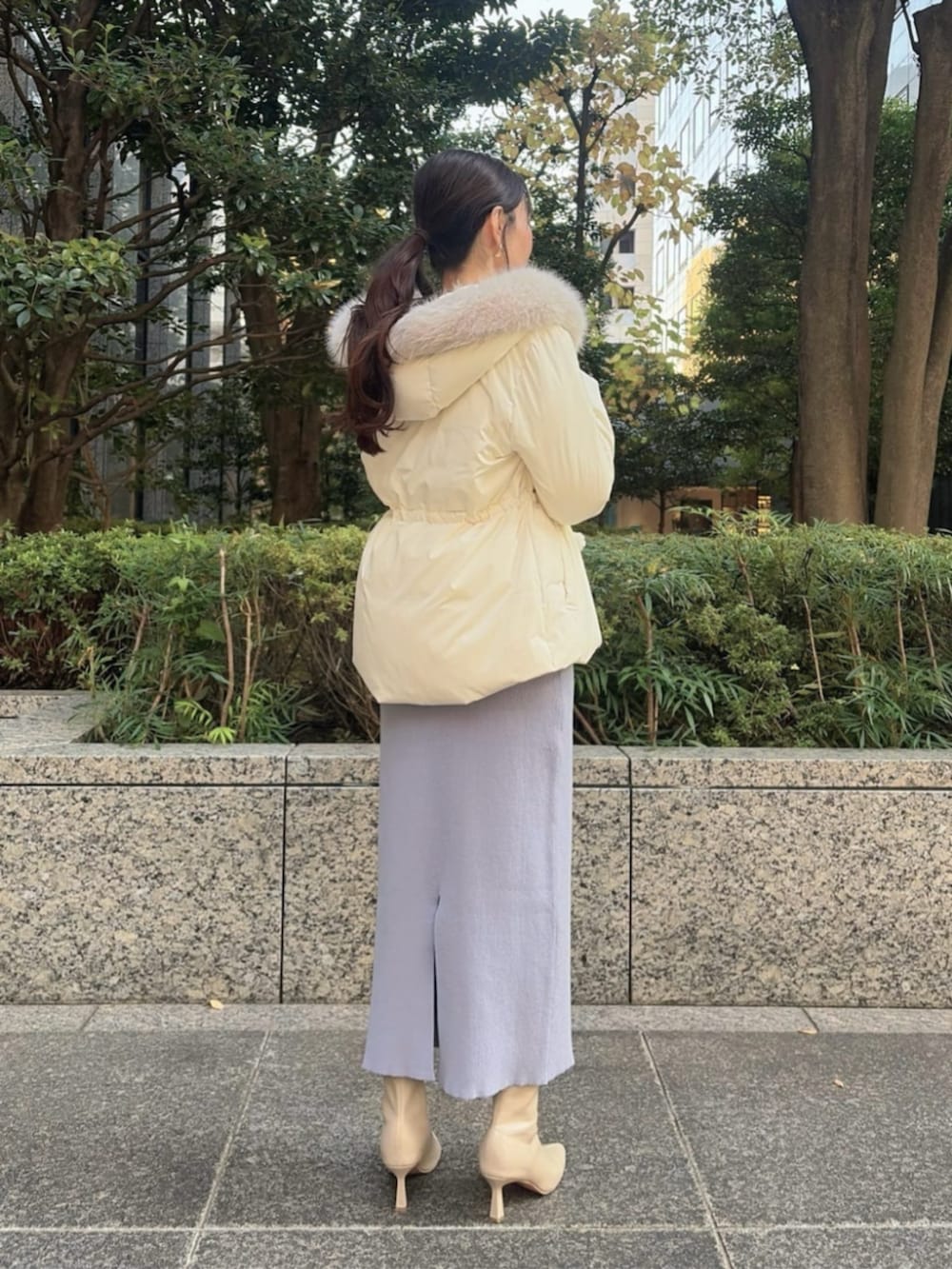 ホワイト系のショルダーバッグ、ホワイト系のダウンジャケット/コート、ブルー系のワンピースを着用したレディースの冬コーディネートの2枚目の写真