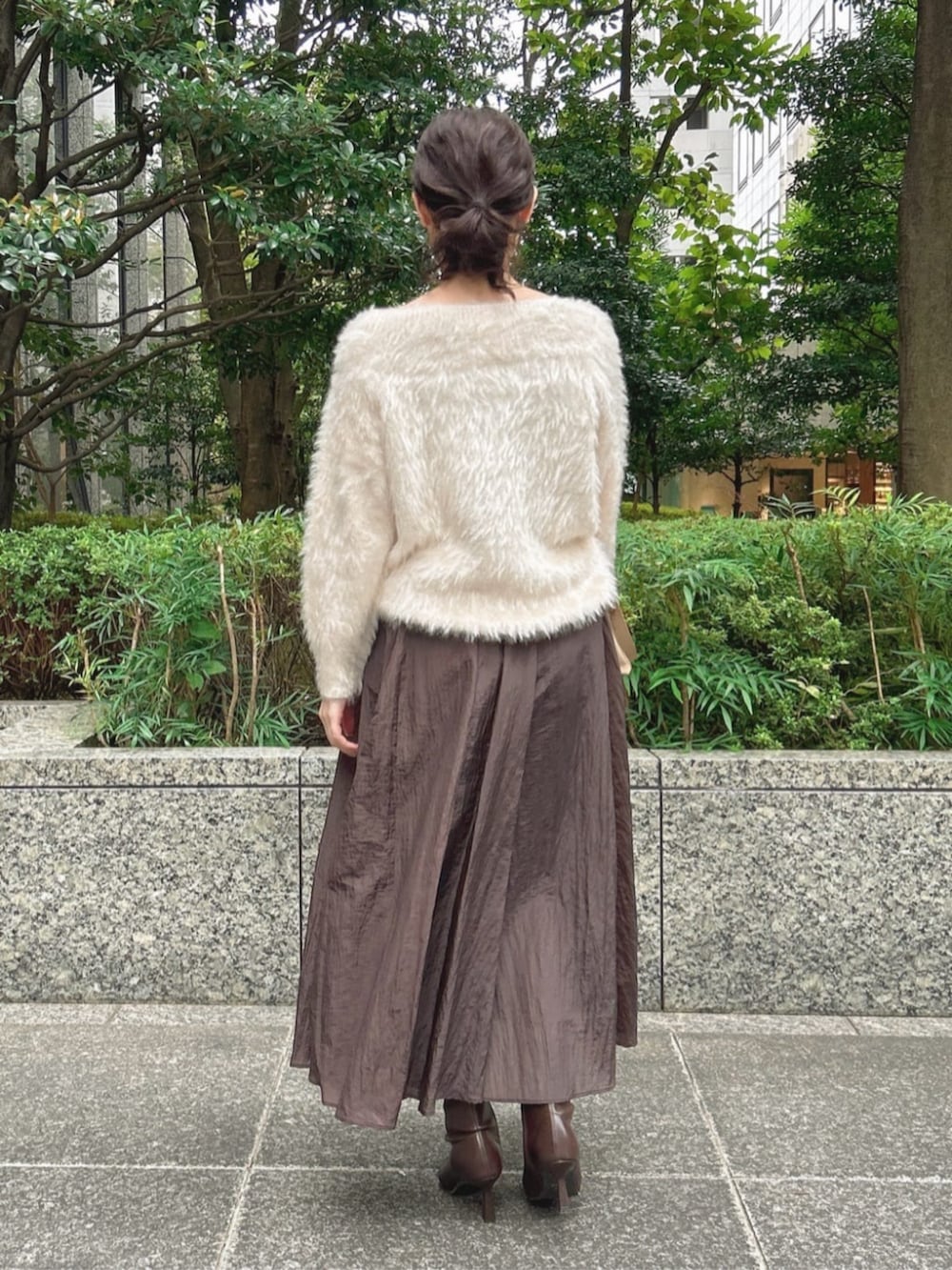 ホワイト系のニット/セーター、ブラウン系のスカート、ベージュ系のショルダーバッグを着用したレディースの秋コーディネートの3枚目の写真