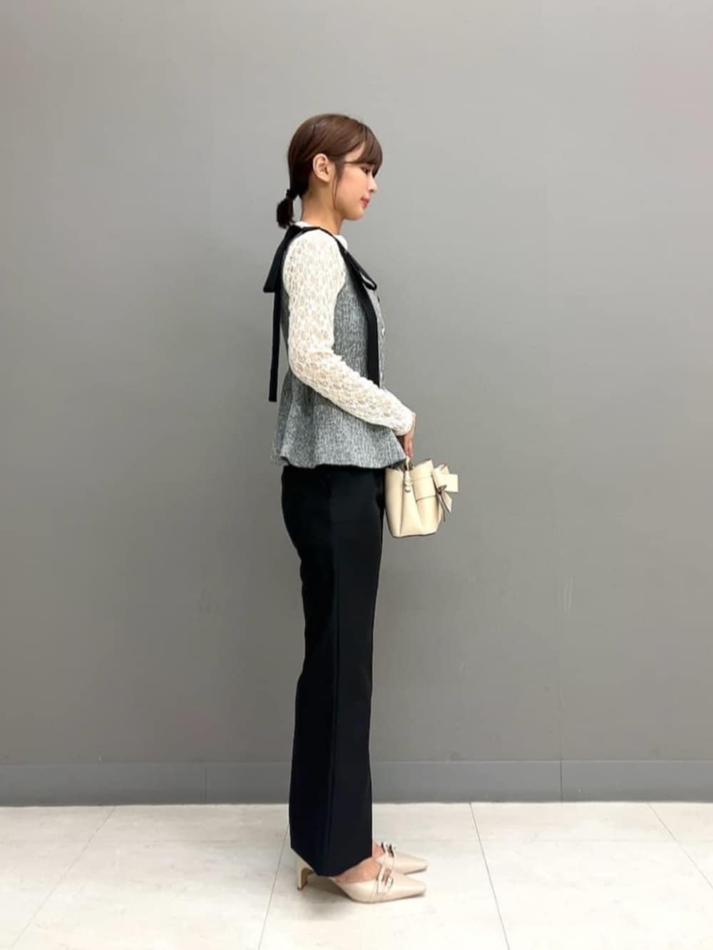 ベージュ系のパンプス、ホワイト系のショルダーバッグ、ブラック系のその他パンツを着用したレディースの秋コーディネートの2枚目の写真