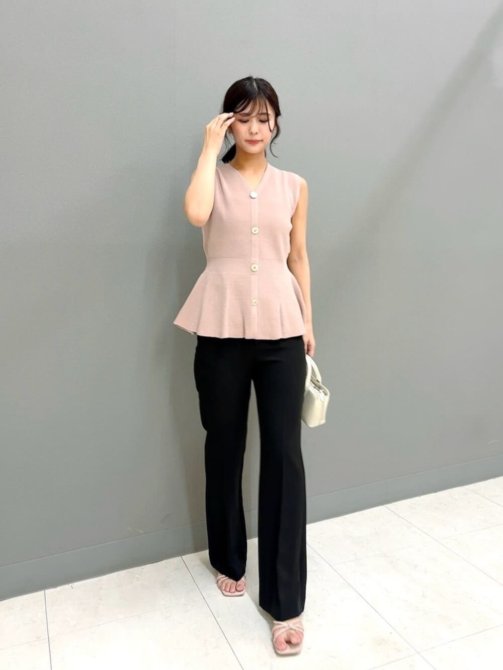 ホワイト系のトートバッグ、ピンク系のニット/セーター、ブラック系のその他パンツを着用したレディースの夏コーディネートの2枚目の写真