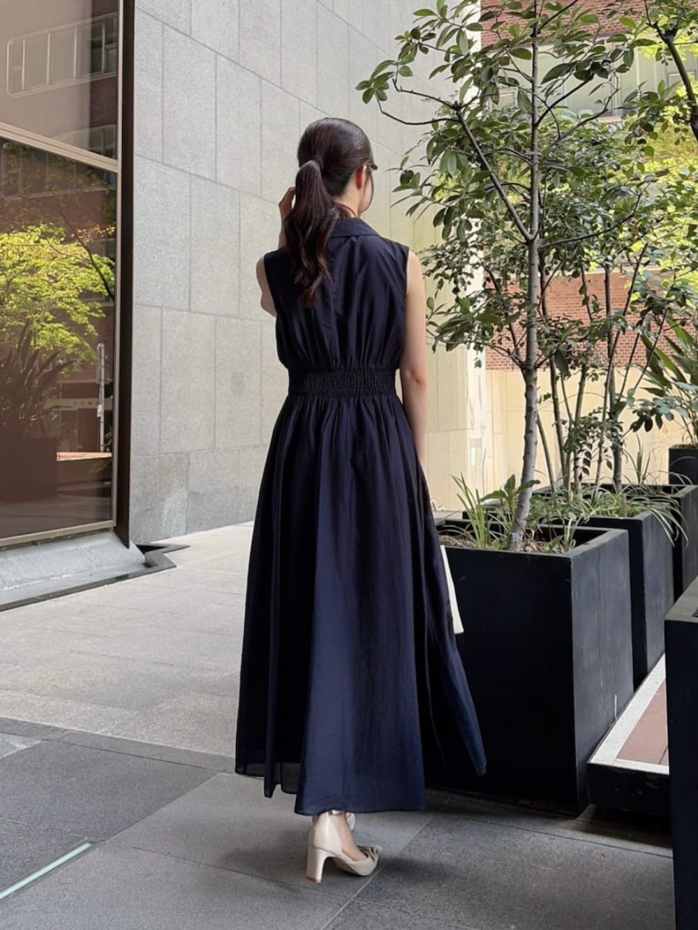 ベージュ系のパンプス、ホワイト系のショルダーバッグ、ブルー系のワンピースを着用したレディースの夏コーディネートの3枚目の写真