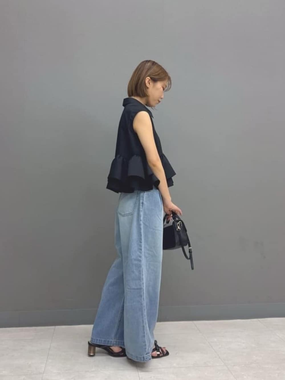 ブラック系のショルダーバッグ、ブルー系のその他パンツ、ブラック系のシャツ/ブラウスを着用したレディースの夏コーディネートの2枚目の写真