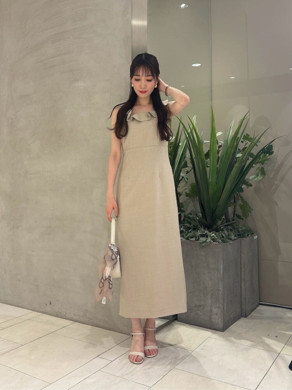 ホワイト系のショルダーバッグ、ベージュ系のワンピース、ベージュ系のストール/ショールを着用したレディースの夏コーディネートの3枚目の写真