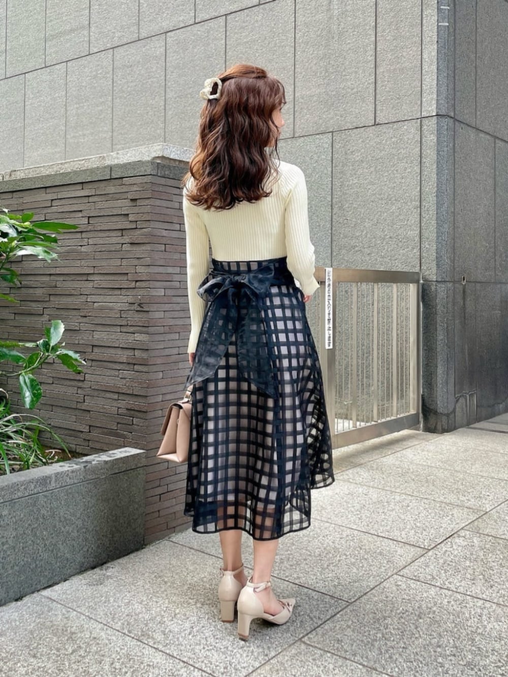 ベージュ系のパンプス、ブラック系のワンピースを着用したレディースの春コーディネートの2枚目の写真